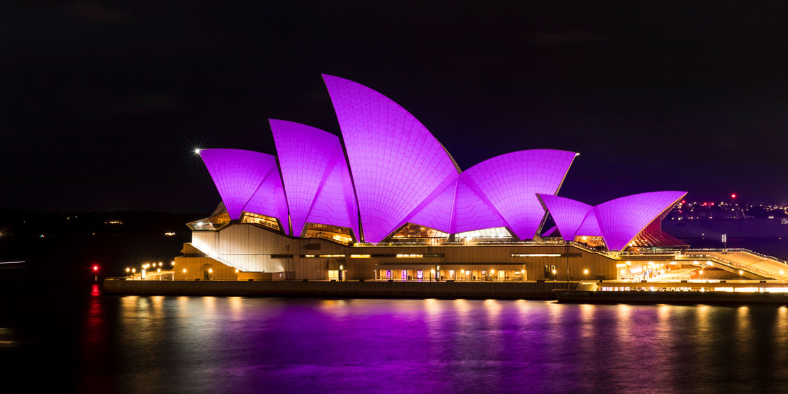 The Sydney Opera House illuminated in royal purple at night