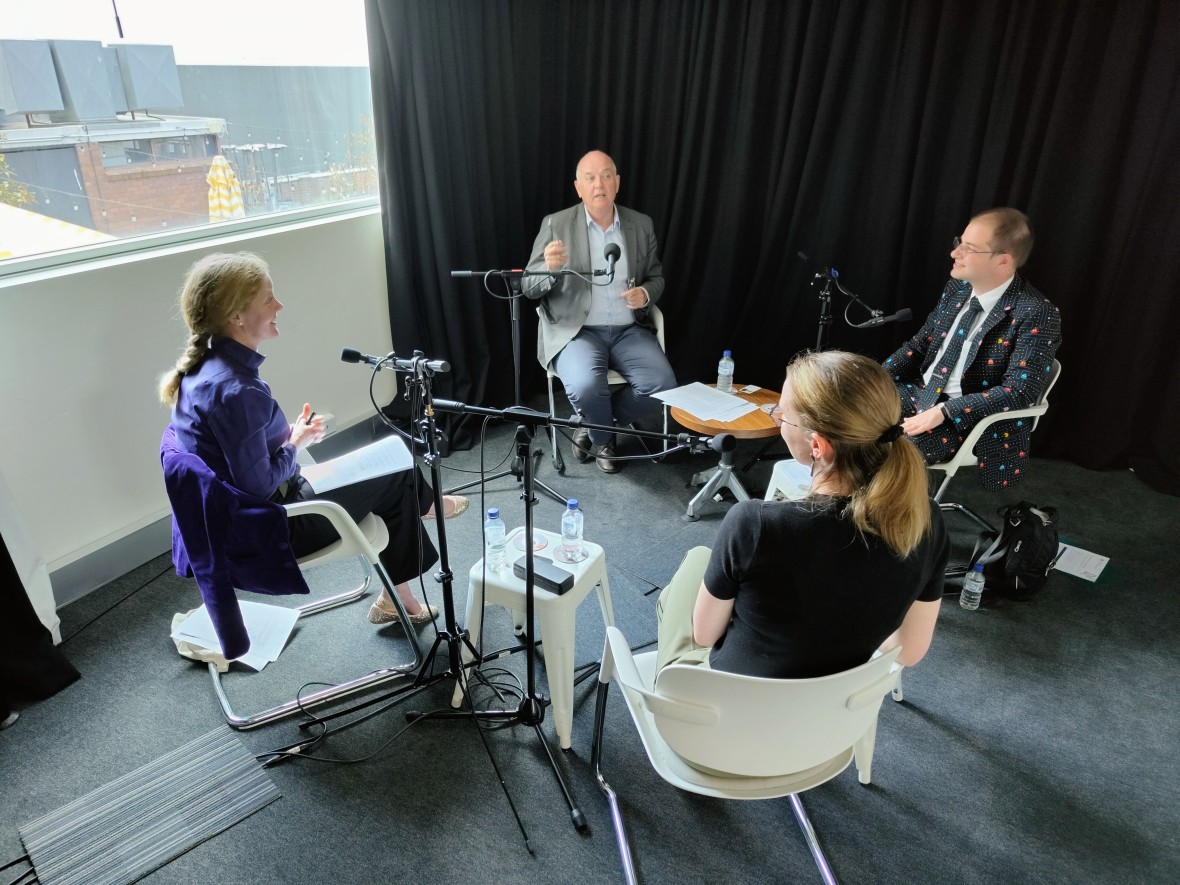 PM&C’s Lee Steel, Robin Edmonds and Andrew Pfeiffer are sitting in a circle with Work with Purpose podcast host, David Pembroke. They are sitting comfortably in a room while recording the podcast. A large window to the left is pouring sunlight into the room. 