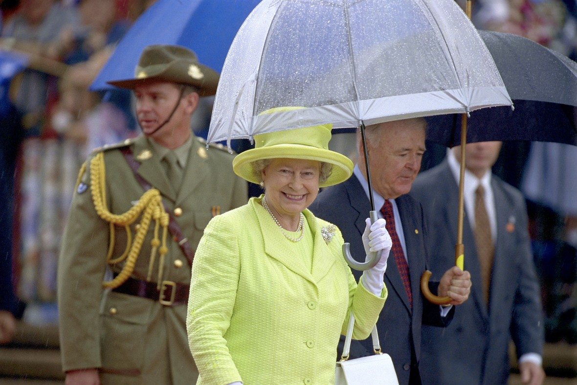 Her Majesty The Queen under a transparent umbrella in the rain
