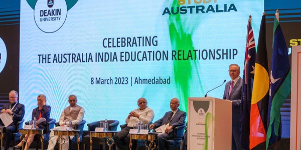 Prime Minister Albanese at the Deakin University podium addressing the attendees. The screen behind them reads, ‘Celebrating the Australia India Education Relationship.’