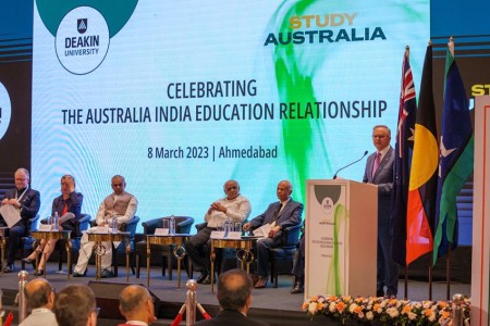 Prime Minister Albanese at the Deakin University podium addressing the attendees. The screen behind them reads, ‘Celebrating the Australia India Education Relationship.’