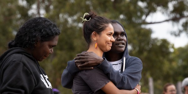 First Nations women hugging each other and smiling.