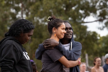 First Nations women hugging each other and smiling.