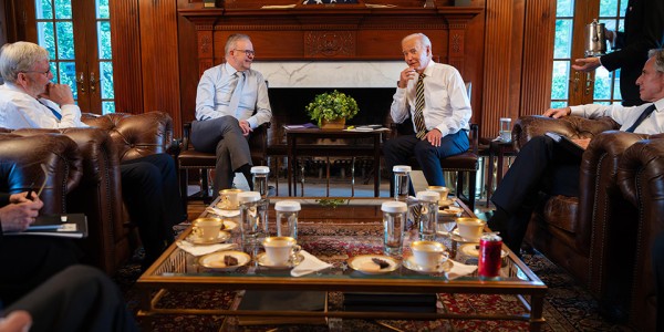 Prime Minister Anthony Albanese sitting with President of the United States Joseph R. Biden Jr., Australia’s Ambassador to the United States Kevin Rudd and US Secretary of State Antony Blinken around a table with tea and coffee.