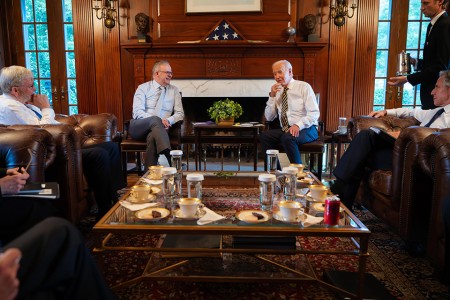 Prime Minister Anthony Albanese sitting with President of the United States Joseph R. Biden Jr., Australia’s Ambassador to the United States Kevin Rudd and US Secretary of State Antony Blinken around a table with tea and coffee.