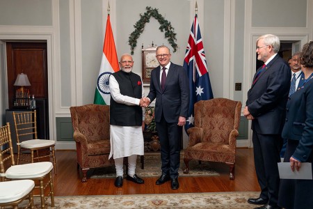 Prime Minister Anthony Albanese shaking hands with Prime Minister Narendra Modi of India in front of the flags of Australia and India.