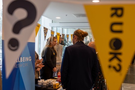 People talking at the PM&C Wellbeing Network R U OK Day pop-up stall.