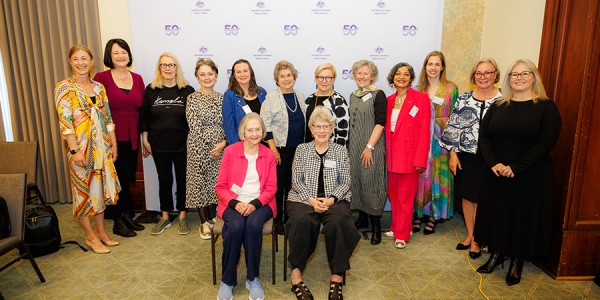 14 women pose for a group photograph while attending an event celebrating the Office for Women’s 50th anniversary.