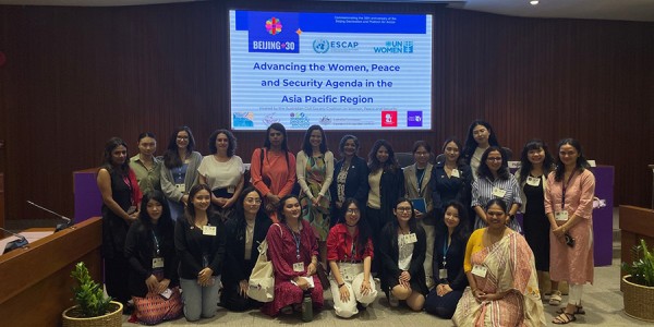 Australia’s Head of Delegation, Ms Padma Raman PSM, and Australia’s Ambassador for Gender Equality, Stephanie Copus Campbell, with a large group in front of a screen that says Advancing the Women, Peace and Security Agenda in the Asia Pacific Region.