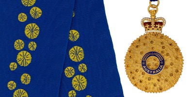 At left is a blue background with yellow flower like designs on it. At right is a gold circular medal with a blue ring in the middle.
