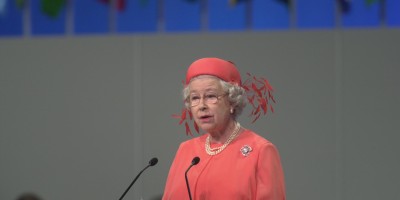 Her Majesty The Queen stands behind a lectern