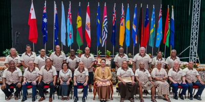 The 53rd Pacific Islands Forum Leaders meeting attendees sitting in two rows in front of the flags.