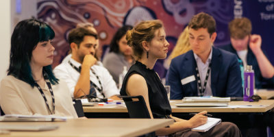 A group of young people watch a speaker