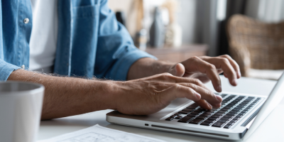 Hands typing on a laptop