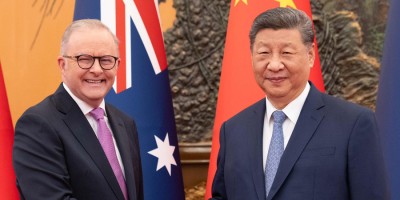 Prime Minister Anthony Albanese and President Xi Jinping smiling at the camera. In the background is the Australian National Flag and