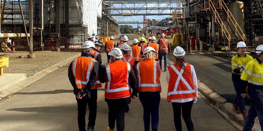 Net Zero Economy Agency wearing high-vis clothing, walking through the site of the Hunter Valley Hydrogen Hub on Kooragang Island.